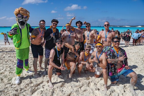A group of people posing for a photo on a beachDescription automatically generated